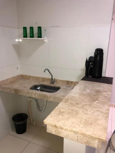 a kitchen counter with a sink in a room at Flat Hotel in Guanamby