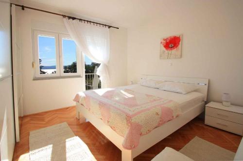 a white bedroom with a bed and a window at Two-Bedroom Apartment in Crikvenica X in Crikvenica
