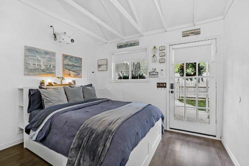 a white bedroom with a bed and two windows at 1 Mi to Lewisville Lake Fun Cozy Couples Retreat in Lake Dallas