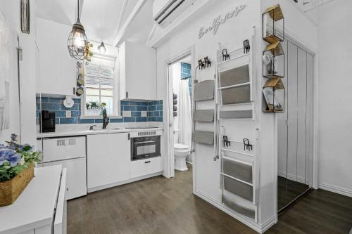 a white kitchen with a sink and a toilet at 1 Mi to Lewisville Lake Fun Cozy Couples Retreat in Lake Dallas