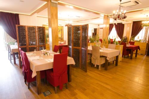 a dining room with tables and red chairs at Winnica Maria Anna in Wyżne