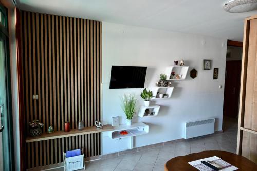 a living room with a television on a white wall at Marie in Krk