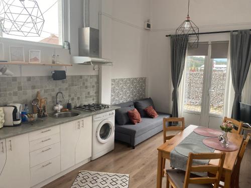 eine Küche und ein Wohnzimmer mit einem Sofa und einem Tisch in der Unterkunft Fressh House in Sîncrăieni