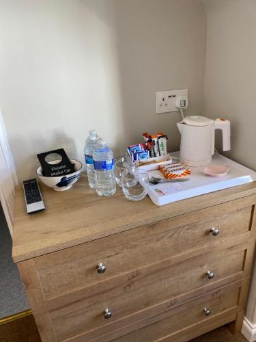 a wooden dresser with a coffee maker and water bottles on it at Honeypot Guest House in Crail