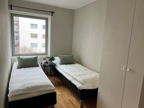 2 Betten in einem Zimmer mit Fenster in der Unterkunft 4-Bedroom-Apt for 7/Oslo Central in Oslo