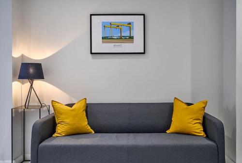 a living room with a couch with yellow pillows at Belfast Luxury Lets - Windsor Townhouse in Belfast