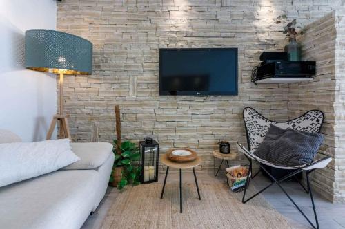 a living room with a couch and a tv on a brick wall at Holiday home in Crikvenica 5239 in Dramalj