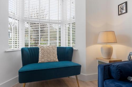 a blue chair in a living room with a window at 9 Riverside in Sidmouth