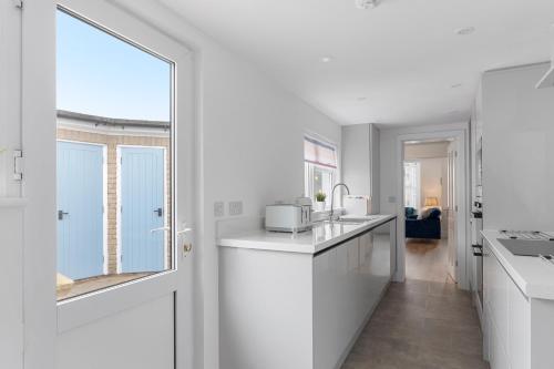 a kitchen with white cabinets and a large window at 9 Riverside in Sidmouth