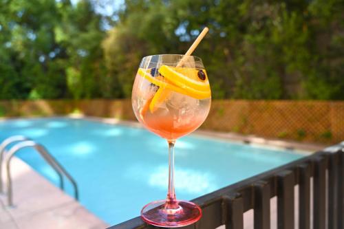 a drink in a glass next to a swimming pool at Novotel Santiago Las Condes in Santiago