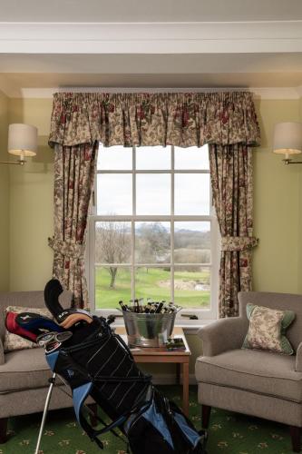 a living room with a window with a dog on the floor at Cally Palace Hotel & Golf Course in Gatehouse of Fleet