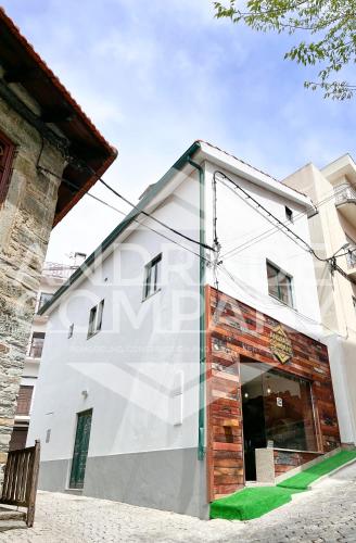 a white building with a bench in front of it at Casa da Padaria Antiga 2 in Pinhão