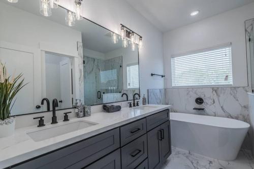 a bathroom with two sinks and a bath tub and a mirror at Your home away from home in Houston