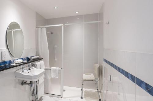 a white bathroom with a sink and a shower at Cally Palace Hotel & Golf Course in Gatehouse of Fleet