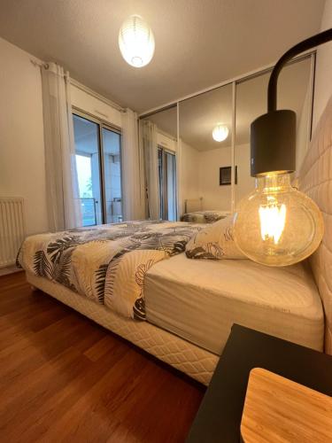 una camera da letto con un letto e un grande specchio di Colomiers Shelter - City, Terrasse, Wifi, Netflix a Colomiers