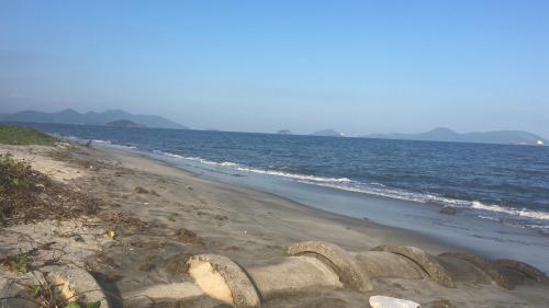 a sandy beach with a view of the ocean at Apartamento Reserva do Sahy - Condomínio Aldeia dos Reis in Mangaratiba
