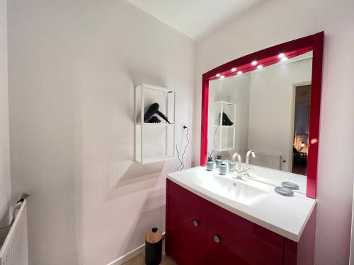 a bathroom with a sink and a red mirror at Colomiers Shelter - City, Terrasse, Wifi, Netflix in Colomiers