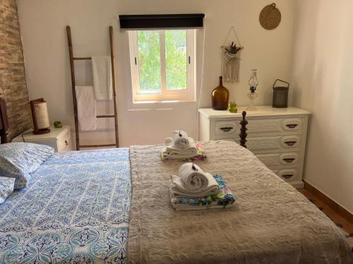 a bedroom with a bed with towels on it at Refúgio dos Sapinhos in Silves