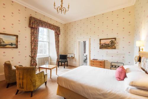 a bedroom with a large bed and a desk at Cally Palace Hotel & Golf Course in Gatehouse of Fleet