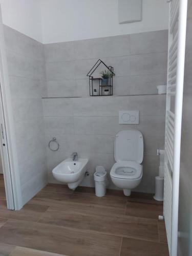 a white bathroom with a toilet and a sink at B&B ANGELA Valdinon in Predaia