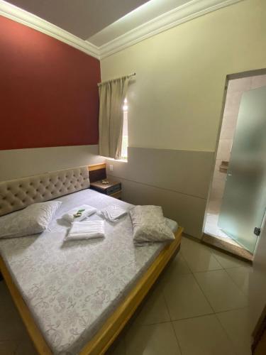 a bedroom with a bed with a towel on it at Namorata Expo Inn in São Paulo