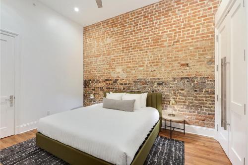 a bedroom with a brick wall and a bed at Roami at Factors Row in New Orleans