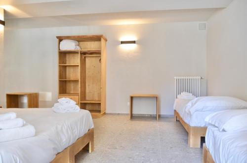two beds in a room with white sheets at Case Verdi in Bardonecchia