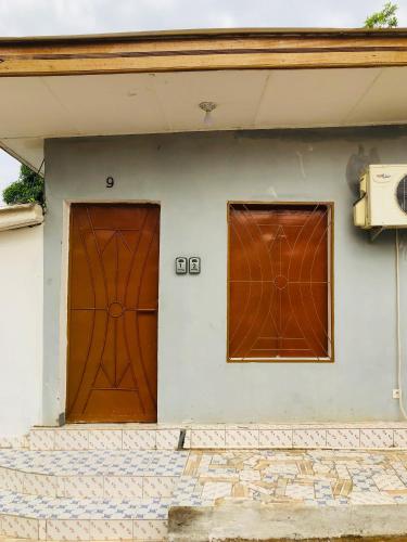 Una casa con dos puertas marrones. en Chez Catherine et Gabriel en Bangui