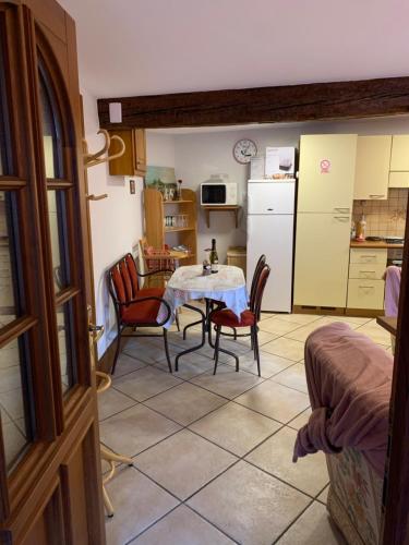 une cuisine avec une table et des chaises dans une pièce dans l'établissement Au Lalli, à Kientzheim