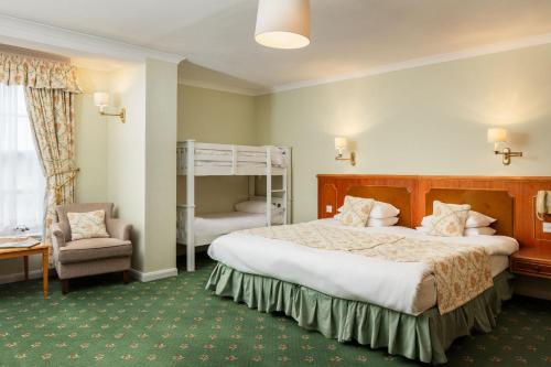 a bedroom with a bed and a bunk bed at Cally Palace Hotel & Golf Course in Gatehouse of Fleet