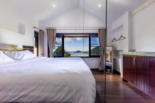 a bedroom with a large bed and a large window at Blue View Amazing 3-Bedroom, Sea View Villa, in Koh Tao