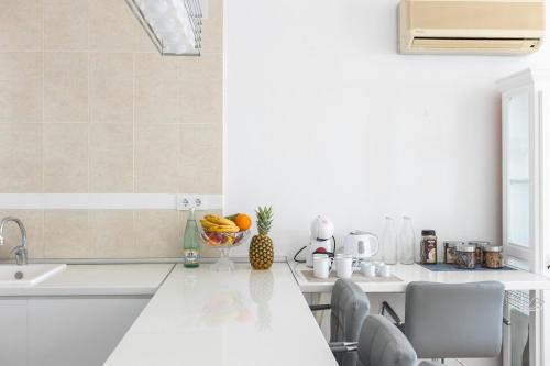 Biała kuchnia ze zlewem i blatem w obiekcie Spacious Apartment in El Poble Nou de Benitatxell, Sea View w mieście Cumbre del Sol