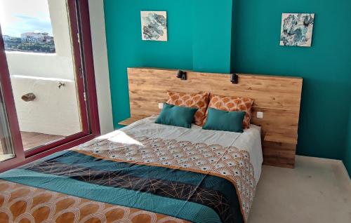 um quarto com uma cama grande e paredes azuis em Appart cosy Golf Garden Casares em Casares
