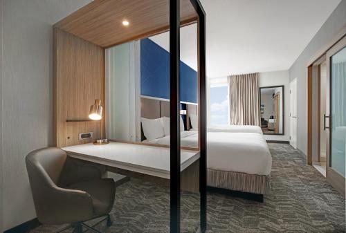 a hotel room with a bed and a chair and a mirror at SpringHill Suites by Marriott Franklin Cool Springs in Franklin
