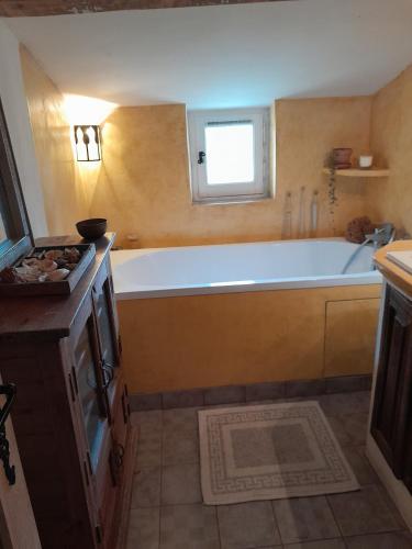 La grande salle de bains est pourvue d'une baignoire et d'une fenêtre. dans l'établissement La maison du Caï, à Reillanne