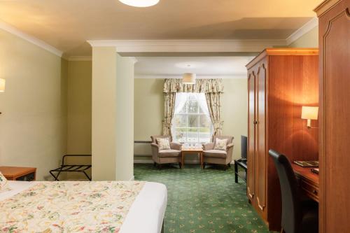 a hotel room with a bed and a desk at Cally Palace Hotel & Golf Course in Gatehouse of Fleet
