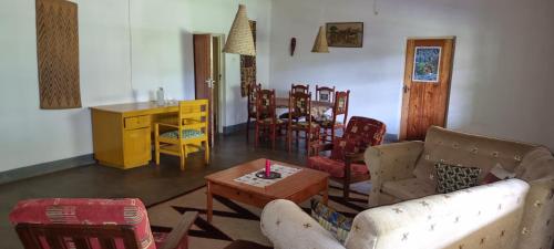 a living room with a couch and chairs and a table at Mutolere Coffee Pot Guest Houses in Kisoro