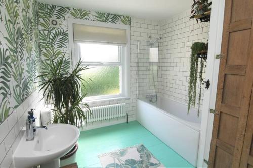 a bathroom with a sink and a tub and a toilet at Welcoming 2 bed townhouse near town centre & beach in Kent