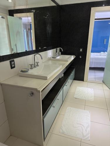 a bathroom with a sink and a large mirror at Residência Angra Deep Blue in Angra dos Reis