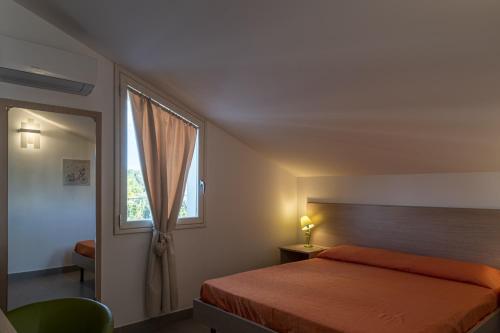 a bedroom with a bed and a window at Borgo Aranci - Appartamento in Villa Rosa - 16B in Castellammare del Golfo
