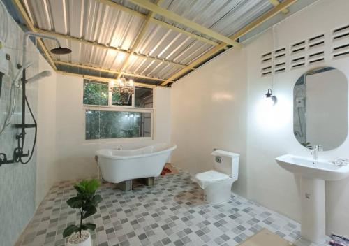 uma casa de banho com uma banheira, um WC e um lavatório. em แม่ไพโฮมสเตย์ ล่องแพกอนโดล่า 