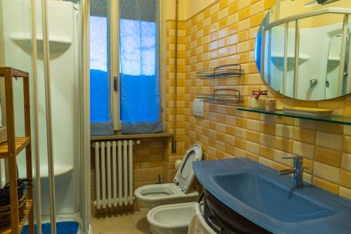 bagno con lavandino blu e servizi igienici di Casa di nonna a Bevagna