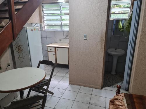 eine kleine Küche mit einem Tisch und einem Waschbecken in der Unterkunft Residencial Mogi das Cruzes in Mogi das Cruzes