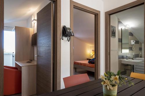a room with a desk and a room with a bedroom at Borgo Aranci - Appartamento in Villa Rosa - 16B in Castellammare del Golfo