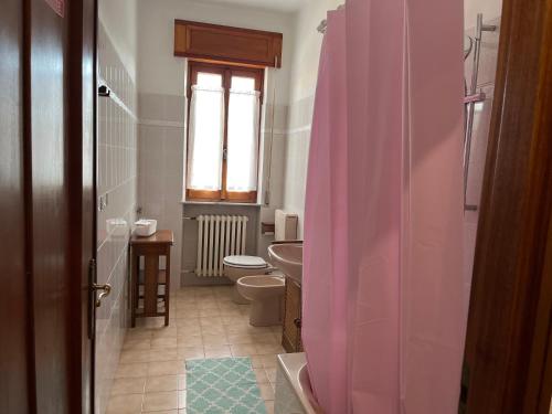 uma casa de banho com uma cortina de chuveiro rosa e um WC. em Casa T Bed and Breakfast & Home Restaurant em Tagliolo Monferrato