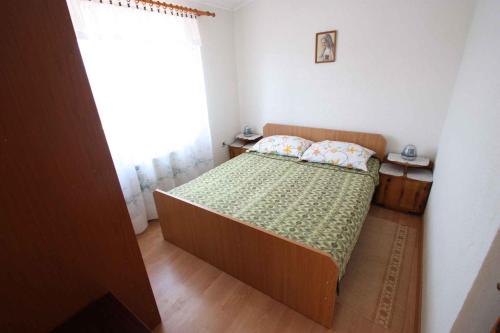 ein kleines Schlafzimmer mit einem Bett und einem Fenster in der Unterkunft Apartments in Jadranovo 39275 in Jadranovo