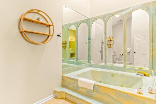 uma casa de banho com uma banheira e um espelho. em No Hurry - 302 em Myrtle Beach
