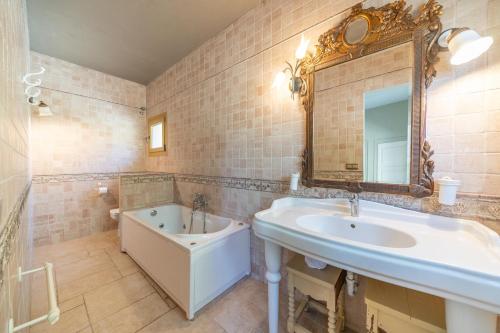 ein Badezimmer mit einem Waschbecken, einer Badewanne und einem Spiegel in der Unterkunft Villa Stephanie in L'Escala