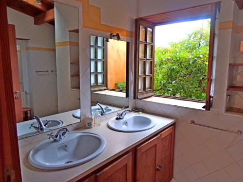 un bagno con due lavandini e un grande specchio di Casa dos Sonhos, private terrace, quiet location, walking to village, ecological pool, pets considered, nature friendly a Barão de São João