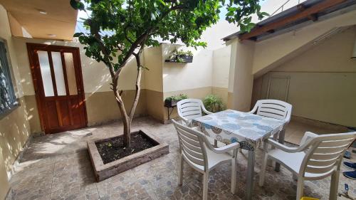 a table and chairs and a tree in a courtyard at Hermosa casa PH equipada y con patio. Aestrenar in Mar del Plata